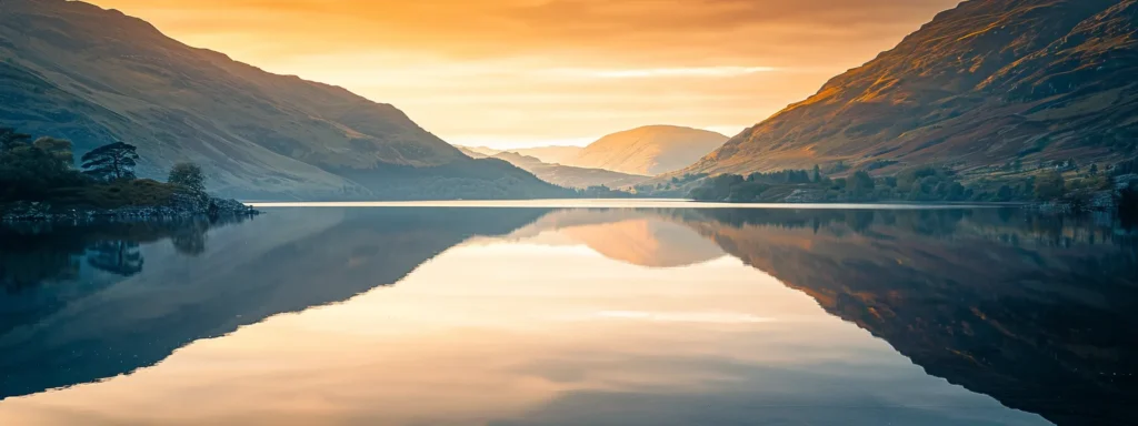 a breathtaking sunrise illuminates a tranquil mountain landscape, casting golden hues on the rugged peaks and reflecting in the still waters of a serene lake.