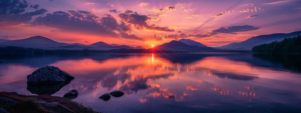 a breathtaking sunset casts vibrant hues of orange and purple across a tranquil lake, reflecting the serene beauty of the surrounding mountains.